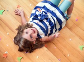 Smiling child laying on timber floor