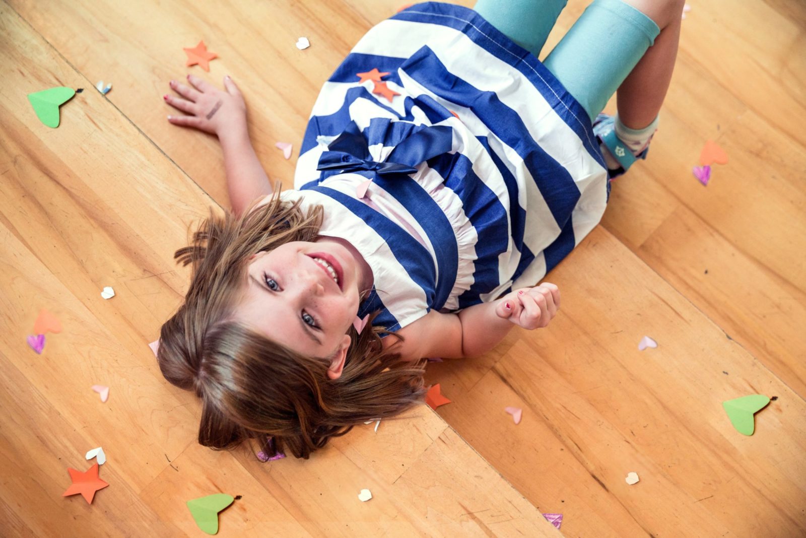 Smiling child laying on timber floor