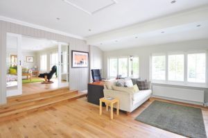 Brightly-lit living room space with timber-style flooring