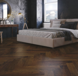 Dark coloured herringbone engineered flooring in bedroom