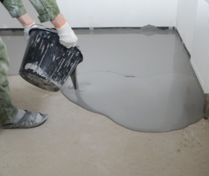 Self-levelling compound being poured onto an unlevel subfloor.